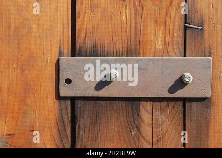 Three Wooden planks and a metal bar. Rusted rectangular plate. Brown boards.  Selective focus. Stock Photo