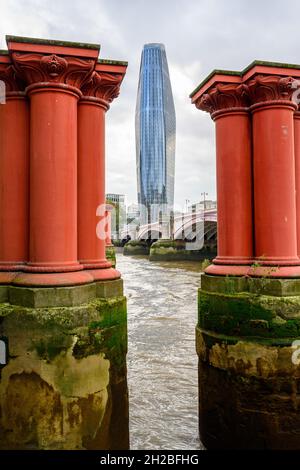 The Boomerang luxury apartments block viewed in between the old, red and disused Blackfriars railway bridge pillars, London, England. Stock Photo