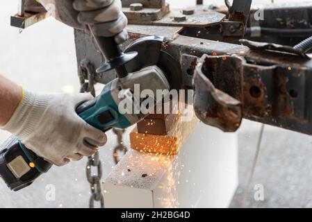 worker using a metal grinder machine to cut off a piece of metal Stock Photo