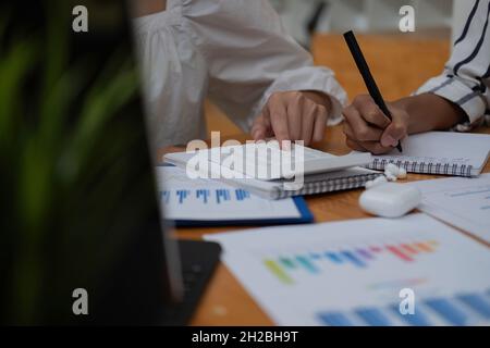 Close up Businessman and partner using calculator and laptop for calaulating finance, tax, accounting, statistics and analytic research concept. Stock Photo