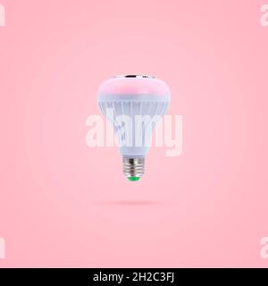 Pink color LED energy saving lamp 230v built-in wireless speakers isolated on pink pastel color background. Stock Photo