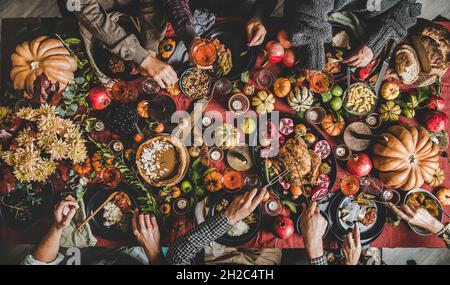 People eating and drinking wine at Thanksgiving celebration dinner table Stock Photo