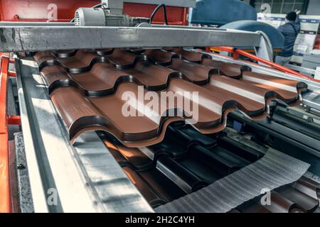 Production line of metal tile for roof. Conveyor belt at metalworking manufacturing plant. Stock Photo