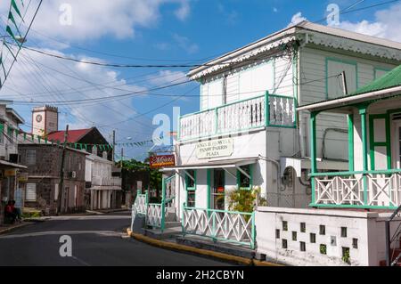 Multiple electrical wires stretch across brightly painted buildings in Charlestown's town center. Charlestown, Nevis Island, West Indies. Stock Photo