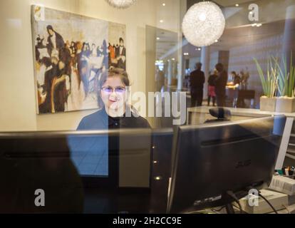 21 October 2021, Rhineland-Palatinate, Mainz: Event manager Franziska Bloch sits at the reception desk in the conference area of the Atrium Hotel in Mainz. At the same time, a press conference of the Rhineland-Palatinate Chambers of Industry and Commerce took place in the hotel about the new employer network "Working Family", to which about 25 family businesses from the hotel and restaurant industry belong. Numerous employees in the hospitality industry have changed industries during the lockdowns in the pandemic, and the number of trainees has declined. This is where the network comes in. Pho Stock Photo
