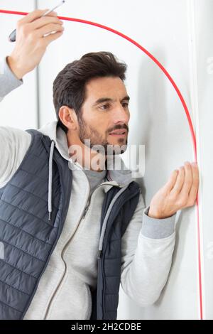 smiling handsome electrician repairing electrical wiring Stock Photo