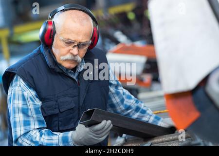 senior worker in metalworking machine Stock Photo