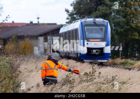 Warngau, Germany. 21st Oct, 2021. An employee of the Bayerische Oberlandbahn gives a warning signal to the train driver on the occasion of a media meeting of the ADAC, the Federal Police, the Bavarian railways and the Deutsche Bahn about dangers at level crossings in order to demonstrate an emergency braking. Credit: Lennart Preiss/dpa/Alamy Live News Stock Photo