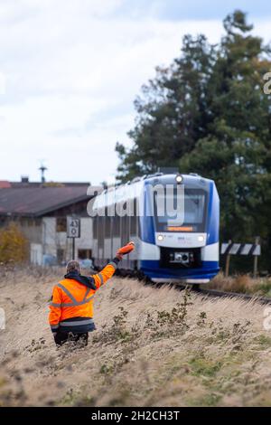 Warngau, Germany. 21st Oct, 2021. An employee of the Bayerische Oberlandbahn gives a warning signal to the train driver on the occasion of a media meeting of the ADAC, the Federal Police, the Bavarian railways and the Deutsche Bahn about dangers at level crossings in order to demonstrate an emergency braking. Credit: Lennart Preiss/dpa/Alamy Live News Stock Photo