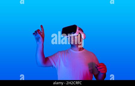 young man using virtual reality glasses using virtual touch screen. Stock Photo