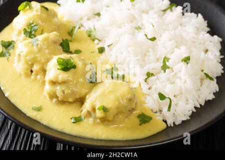 Popular Danish family dish boller i karry or meatballs in curry sauce with rice close up in the plate on the table. horizontal Stock Photo