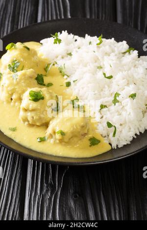 Boller i Karry Pork Meatballs in mild Curry with rice close up in the plate on the table. Vertical Stock Photo