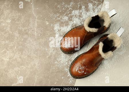 Boots with snow on two tone background. Stock Photo