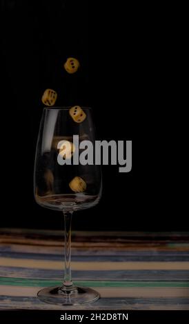 Transparent dirty glass with color dice on color wooden table Stock Photo