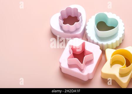Multicolored cookie molds cutters on pink background with copy space for your advertisement and text. Baking concept. Flat lay. Mock up. Stock Photo