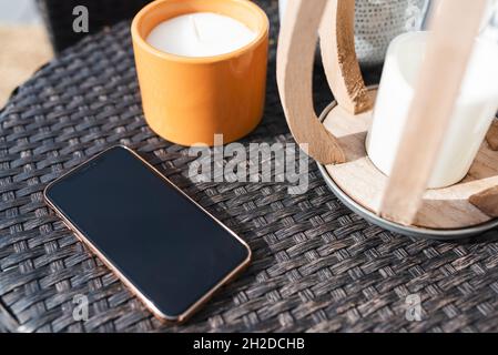 iPhone on a patio side table in the summer with candles Stock Photo