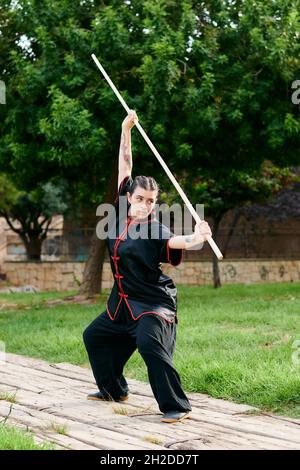 Woman in uniform practicing martial arts with a stick Stock Photo