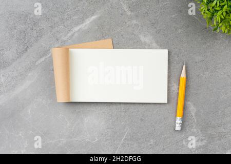 Open notepad on gray marble background. Stock Photo