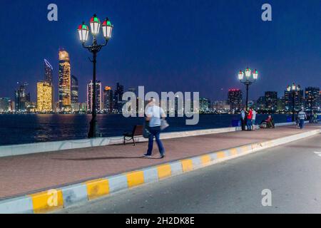 ABU DHABI, UAE - MARCH 7, 2017: People watch the skyline of Abu Dhabi from the Marina Breakwater, United Arab Emirates Stock Photo