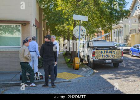 NEW ORLEANS, LA, USA - OCTOBER 17, 2021: Musicians standing by with musical instruments and Piano on a Truck Sign on pickup truck in Bywater Neighborh Stock Photo