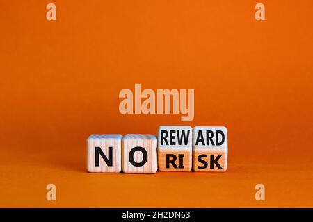 No risk or reward symbol. Turned cubes and changed words 'no risk' to 'no reward'. Beautiful orange background. No risk or reward and business concept Stock Photo