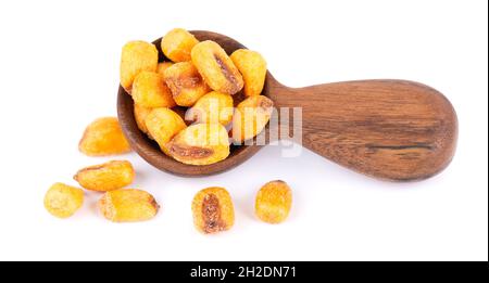 Roasted salted corn nuts in wooden spoon, isolated on white background. Beer snack, dry corn with spices. Stock Photo
