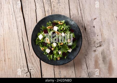 Beetroot salad with feta cheese,lettuce and walnuts on rustic wooden table Stock Photo