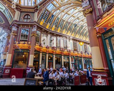 Customers drinking and socialising at tables outside Lambs Tavern in historic Leadenhall Market in Gracechurch Street in the City of London, EC3