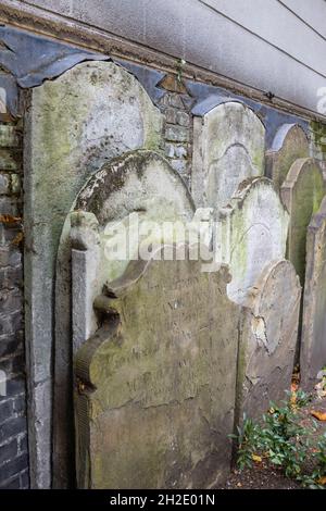 Ancient 18th century headstones next to the Watts Memorial to Heroic Self Sacrifice in Postman's Park in London EC1 Stock Photo