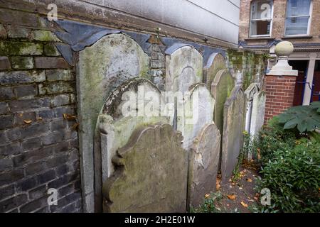 Ancient 18th century headstones next to the Watts Memorial to Heroic Self Sacrifice in Postman's Park in London EC1 Stock Photo