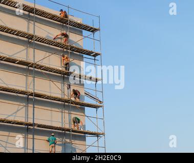 UZHGOROD, UKRAINE - Sep. 16, 2021: Construction workers putting decorative plaster on house exterior. Facade thermal insulation and painting works Stock Photo