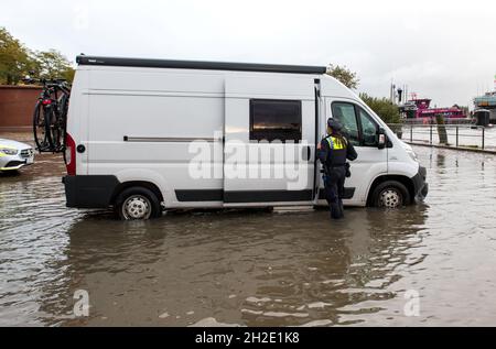 Hamburg, Germany. 21st Oct, 2021. A policewoman talks to the driver of a camper van in the evening at the fish market, which was flooded during the floods. Credit: Daniel Bockwoldt/dpa/Alamy Live News Stock Photo