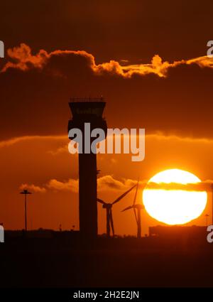 Castle Donington, Derbyshire, UK. 21st October 2021. UK weather.  The sun sets behind the control tower at East Midlands Airport. Credit Darren Staples/Alamy Live News. Stock Photo