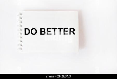Text DO BETTER on notepad and white background. The concept of no excuses and procrastination. Stock Photo