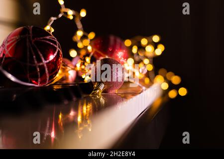 Festive decor on piano keys indoors, closeup. Christmas music Stock Photo