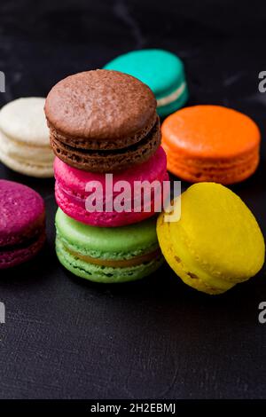 Colorful macarons cookies on the black background Stock Photo