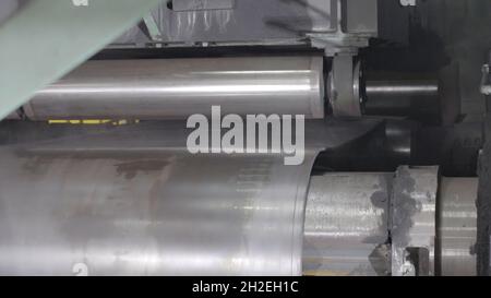 Forming machine for corrugated steel plate. Manufacture of pipes. Industrial machine close up. Stock Photo