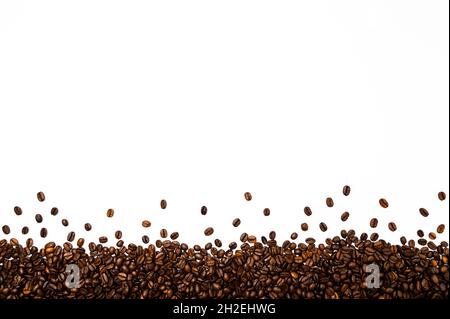 Roasted coffee or espresso beans border or frame against white background. Stock Photo