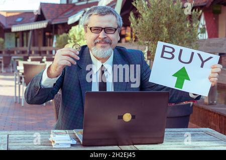 Man calls for the sale of the bitcoin cryptocurrency. He trades on a cryptocurrency exchange via a laptop. Stock Photo