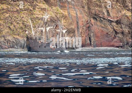 Renovated old wooden pirate ship sailing along coast. Stock Photo