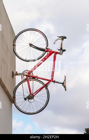 racing road bike mounted vertically on wall of velotel bicycle hire shop in Can Pastilla near Palma Mallorca Spain Stock Photo