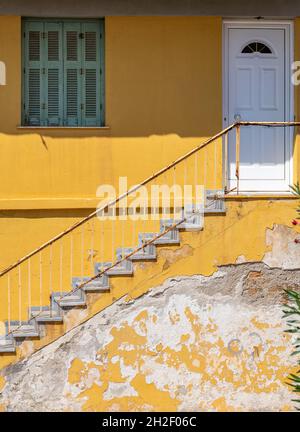 yellow painted wall and flight of steps with white front door on a greek building. bright yellow stairs and steps, flight of steps, staircase, yellow, Stock Photo