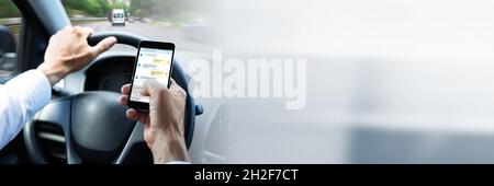 Man Typing Text Message On Mobile Phone While Driving Car Stock Photo