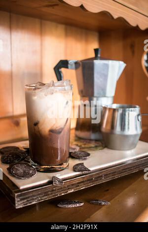 Ready to drink delicious chocolate iced coffee on tray with chocolate, sleek wooden vibes Stock Photo