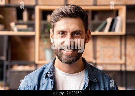 Face portrait of positive smiling businessman freelancer in home office interior Stock Photo