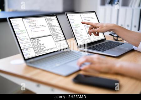 Programmer Woman Coding On Multiple Computer Screens Stock Photo