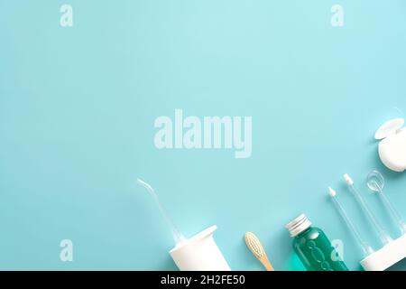 Dental care products on blue background. Flat lay composition with water flosser irrigator, mouthwash, dental floss, toothbrush. Stock Photo