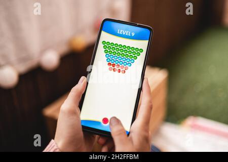 Girl gamer playing blockchain game online on mobile phone - Crypto currency technology trends Stock Photo