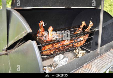 Whole spit-roasted pig hog on a charcoal-fired grill outside, on a Midwestern farm, Blanchardville, Wisconsin, USA Stock Photo