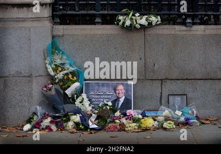 London, UK. 19th Oct, 2021. Flowers and messages are left outside the entrance to the House of Commons, Westminster as a tribute to murdered conservative MP Sir David Amess. He was murdered by a knifeman during his constituency surgery in Leigh-on-Sea. The man has been detained under the Terrorism Act. Credit: SOPA Images Limited/Alamy Live News Stock Photo